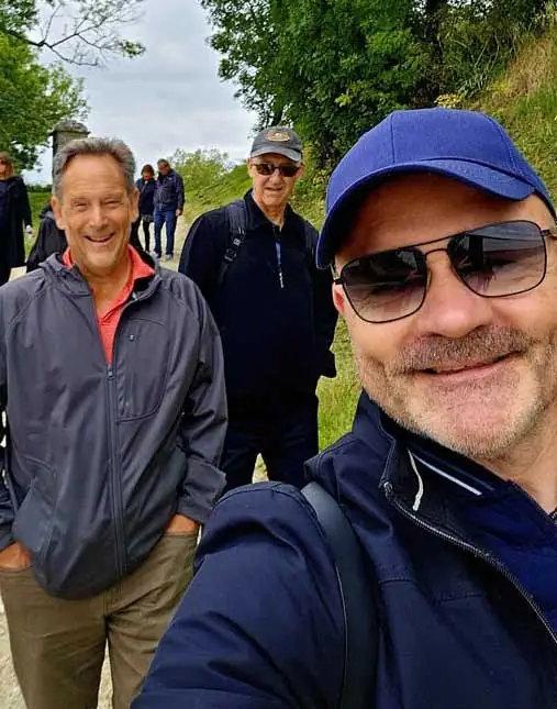 Bruno Saint-Clair et un groupe de visiteurs souriants pendant une balade guidée